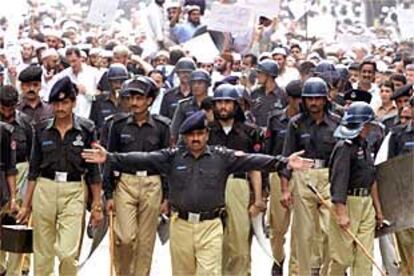 Policías antidisturbios paquistaníes se sitúan al frente de una manifestación contra EE UU en la ciudad de Peshawar.