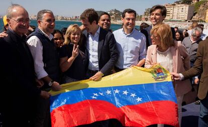 El presidente del PP, Pablo Casado, posa en Málaga, junto a representantes del PP andaluz, con una bandera venezolana. 
 