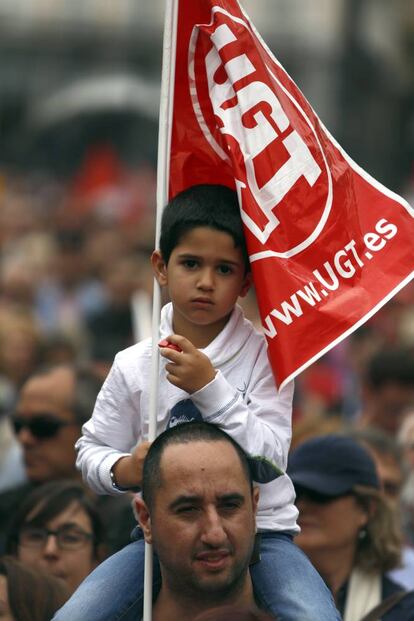 Un hombre con su hijo a hombros y una bandera de UGT en la manifestación del Primero de Mayo en Madrid, en 2015.