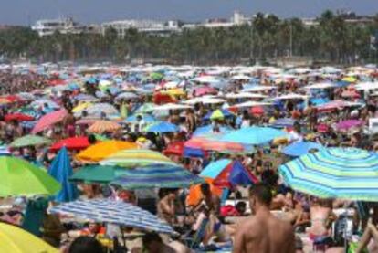 Imagen de la Playa de Levante de Salou repleta de turistas este mediod&iacute;a en el primer domingo de las vacaciones de Agosto. 