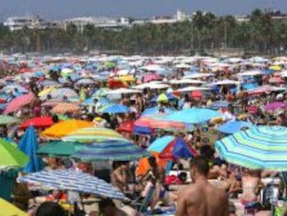 Imagen de la Playa de Levante de Salou repleta de turistas este mediod&iacute;a en el primer domingo de las vacaciones de Agosto. 