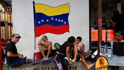 Migrantes venezolanos, ante una pintura de la bandera de su país, en Ciudad Hidalgo (México), preparándose para viajar a la frontera de México con EE UU, el 5 de junio.