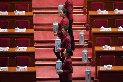 Azafatas llevan jarras de té caliente para servir a los líderes chinos antes de una sesión plenaria de la Asamblea Popular Nacional, el 9 de marzo de 2018.