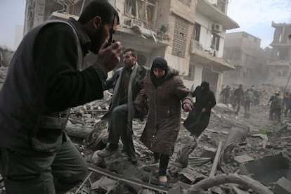 Un grupo de personas huye tras un ataque aéreo en Saqba (Siria).