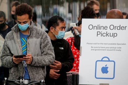 FILE PHOTO: FILE PHOTO: A customer has his temperature taken while in line outside an Apple Store to pick up Apple's new 5G iPhone 12 in Brooklyn, New York