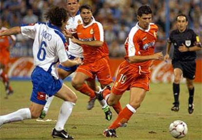 El argentino Milito, del Zaragoza, (izqda.) intenta arrebatar el balón a Luque.