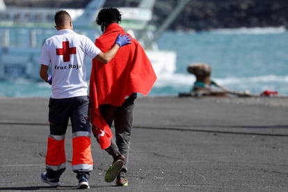 Un voluntario de la Cruz Roja acompaña a un inmigrante en el puerto de Arguineguin