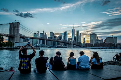'Viaje familiar por la Gran Manzana'. Varias personas contemplan el atardecer en Brooklyn con Manhattan al fondo. Nueva York, 7 de agosto de 2022.