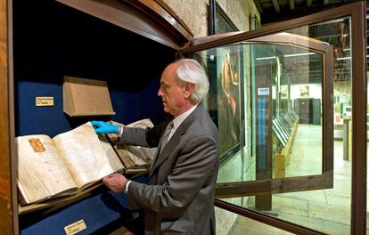 Samuel Rubio, canónigo de la Catedral de León, manipula el códice en la vitrina del museo.