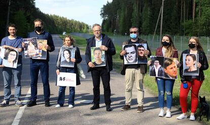 El secretario ejecutivo de Reporteros Sin Fronteras (RSF), Christophe Deloire (en el centro) y otros activistas sostienen fotografías del periodista detenido en Bielorrusia Roman Protasevich y otros informadores arrestados.