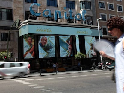 Una mujer pasa por delante del cine Capitol, abanico en mano.