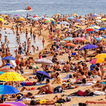Crowds of tourist on Barceloneta beach, Barcelona, Spain