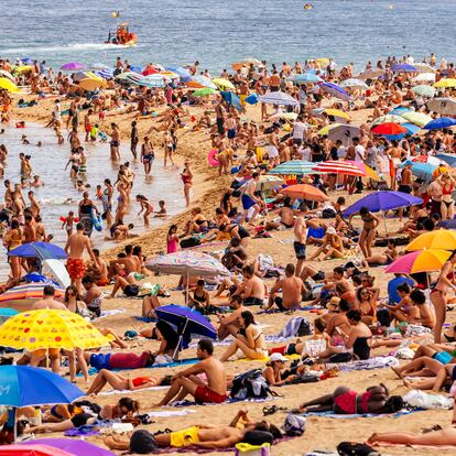 Crowds of tourist on Barceloneta beach, Barcelona, Spain