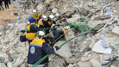 Voluntarios de los Cascos Blancos trabajan para sacar de los escombros a víctimas y personas atrapadas bajo un edificio residencial derrumbado en la ciudad de Sarmada, al norte de Idlib.