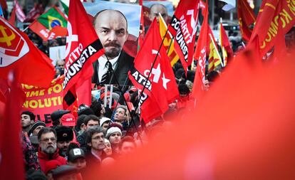 Un grupo de personas, que portan banderas rojas y retratos de Lenin, participa en una manifestación con motivo de los cien años de la Revolución Rusa, en Moscú (Rusia).