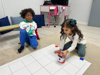 Dos alumnos de cuatro y cinco años del CEIP Gumersindo Azcárate (León) en el Aula del Futuro del centro, programando un robot para que siga una ruta determinada por el tapete cuadriculado.