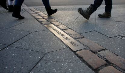 Pessoas caminham sobre os paralelepípedos que marcam a antiga divisão do Muro de Berlim (Alemanha), em 5 de fevereiro de 2018.