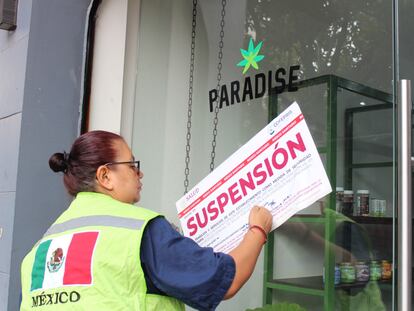 Una inspectora de la Cofepris coloca un sello de suspension en la entrada de una tienda Paradise, en el centro de Ciudad de México.