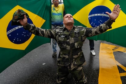 Un bolsonarista vestido con ropa militar, se arrodilla frente a un par de banderas brasileñas durante una de las manifestaciones de este miércoles, en Río de Janeiro.