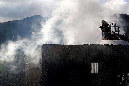 Bomberos del Gobierno de Navarra y agentes de la Policía Foral trabajan en el incendio que lunes ha calcinado una vivienda en la localidad de Artaiz (Unciti).