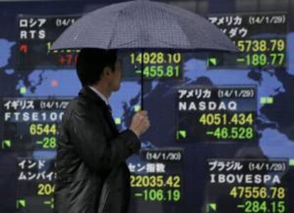 Un hombre pasa por delante de una pantalla con los resultados de la Bolsa de Tokio, en Japón.