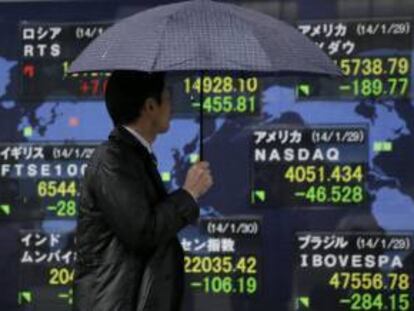 Un hombre pasa por delante de una pantalla con los resultados de la Bolsa de Tokio, en Japón.