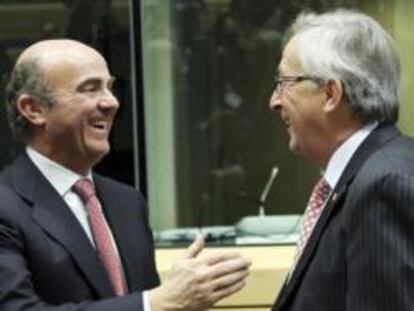 El ministro de Economía y Competitividad, Luis de Guindos, conversa con el presidente del Eurogrupo, Jean-Claude Juncker, y con el ministro de Finanzas galo, François Baroin