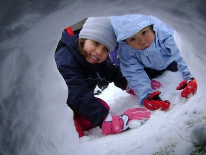 Dos ni&ntilde;os construyendo un igl&uacute; de nieve en una de las actividades de Solomonte Experiencias, en en Pirineo de Huesca.  