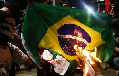 Un grupo quema una bandera de Brasil durante una protesta contra el Mundial.