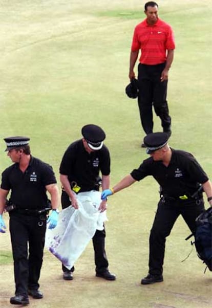 Miembros de la policía recogen en una bolsa objetos lanzados por los espectadores.