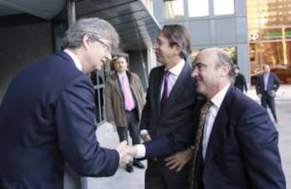 El presidente de KPMG , John Scott,iz, y el presidente de Efe, José Antonio Vera,c., saludan al ministro de Economía y Competitividad, Luís de Guindos, a su llegada a la sede de la Agencia Efe donde interviene en el primer Foro Líderes que organizan la Agencia EFE y KPMG, un encuentro que reúne a personalidades del mundo económico y empresarial.