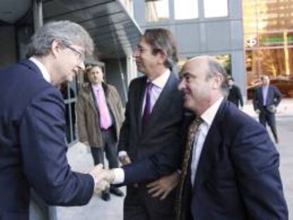 El presidente de KPMG , John Scott,iz, y el presidente de Efe, José Antonio Vera,c., saludan al ministro de Economía y Competitividad, Luís de Guindos, a su llegada a la sede de la Agencia Efe donde interviene en el primer Foro Líderes que organizan la Agencia EFE y KPMG, un encuentro que reúne a personalidades del mundo económico y empresarial.