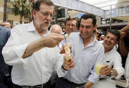 Mariano Rajoy (i), junto al líder del PP-A, Juanma Moreno (c), se toma un helado frente al Ayuntamiento de Adra, Almería.