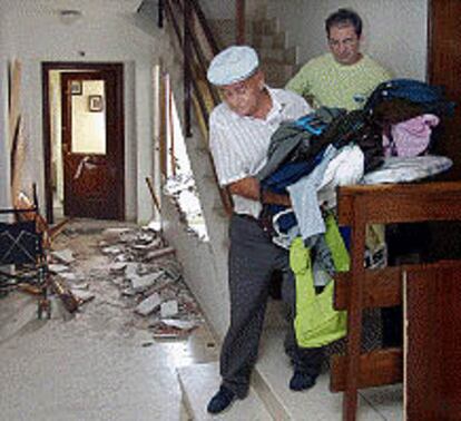 Dos vecinos de Santa Pola, ayer, recogen ropa y enseres personales en su casa, afectada por la explosión.