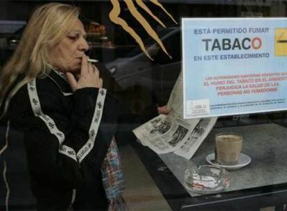 Una mujer fuma en una cafetería madrileña.