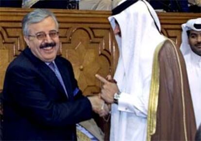 El ministro de Exteriores iraquí (dcha)  saluda a su homólogo quatarí en la reunión de El Cairo.