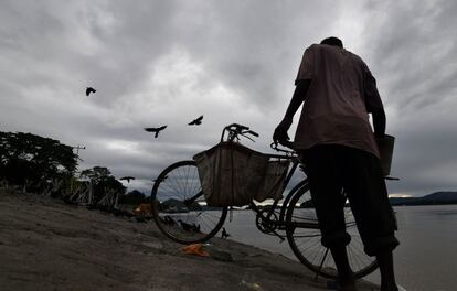 Un vendedor indio de pescado lava su bicicleta después de vender sus peces en la orilla del río Brahmaputra, en Guwahati (India)