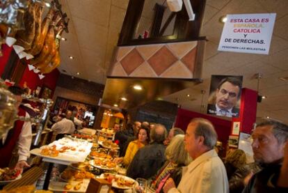 El dueño del asador Guadalmina de Marbella, José Eugenio Arias Camisón, explica la reapertura del local delante de los carteles que prohíben fumar. Arias Camisón fue multudo y su local clausurado por incumplir la ley antitabaco y dejar consumir cigarrillos y puros en el establecimiento.