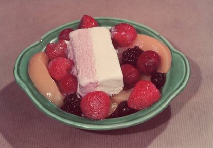 Un postre con guindas y frutas en almíbar.