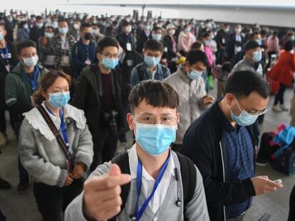 Viajeros con mascarilla en Hubei, China.