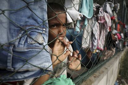 Un niño mira a través de una cerca en un refugio instalado en un centro comunitario en Arauquita, Colombia, el jueves 25 de marzo de 2021, en la frontera con Venezuela.