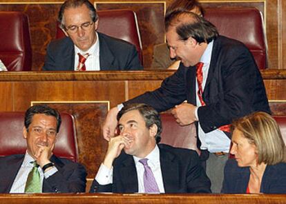 Diputados del PP, durante el pleno extraordinario de ayer. En primer término, de izquierda a derecha, Eduardo Zaplana, Ángel Acebes, Alicia Castro y, de pie, Vicente Martínez Pujalte. Detrás, Sebastián González.