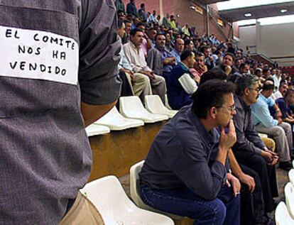 Un trabajador porta en la espalda un cartel contra el comité durante la asamblea de ayer en Santana.