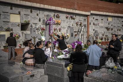 La familia Maya de la Rosa preparando la decoracion floral en la tumba de sus familiares en el madrileño cementerio de La Almudena.