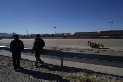 Dos trabajadores toman un descanso en las orillas del río Grande, donde el Papa Francisco dará Misa el 17 de febrero en Ciudad Juárez, al otro lado, en Estados Unidos, una retroexcavadora realiza tareas de limpieza.