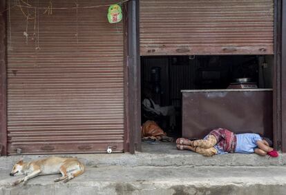Un jornalero duerme una siesta durante sexagesimoséptima jornada del confinamiento impuesto para frenar la pandemia del coronavirus en Katmandú, Nepal.