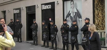 La policía custodia la entrada de comercios del centro de Madrid.