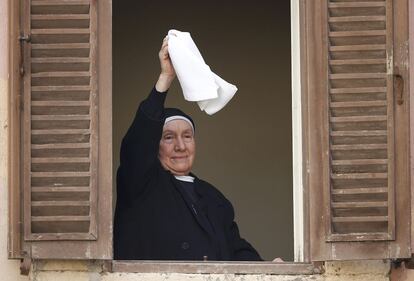 Una monja se despide con un pañuelo de Benedicto XVI desde un balcón de la plaza de Castel Gandolfo.