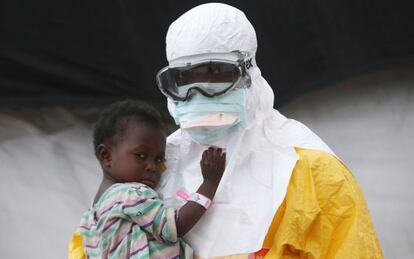 Un trabajador de Médicos Sin Fronteras sujeta un niño sospechoso de estar infectado por ébola en Liberia.