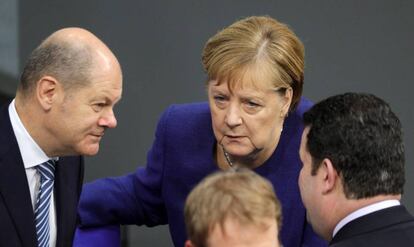 La canciller alemana, Angela Merkel, con el ministro de Finanzas, Olaf Scholz (izq.) este jueves en el Parlamento en Berlín.